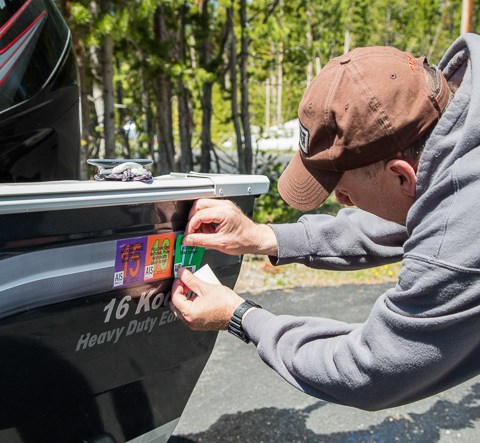 Applying a Yellowstone AIS sticker to a boat
