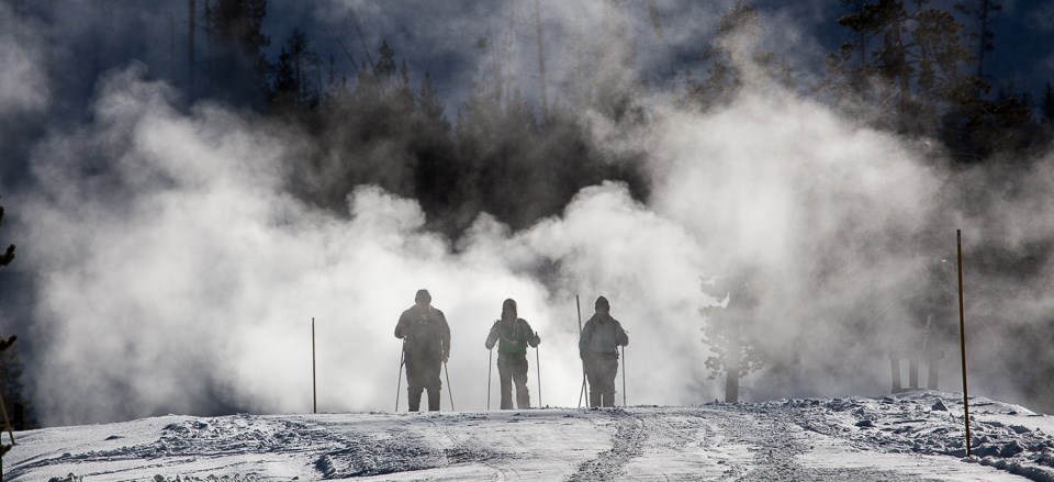 Three skiers on the road in Black Sand Basin