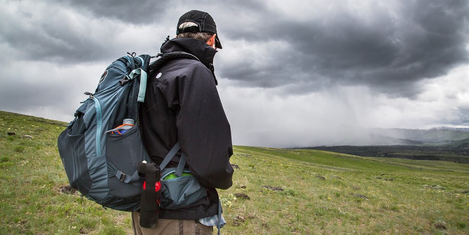 A hiker watches an oncoming storm on Specimen Ridge