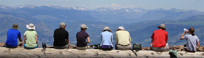 Visitors sitting at the top of Mt. Washburn.