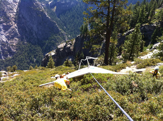 Hang glider and rescuers in brush