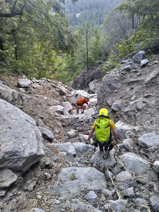 Rescuer and hiker descending steep canyon Rescuer and hiker descending steep canyon
