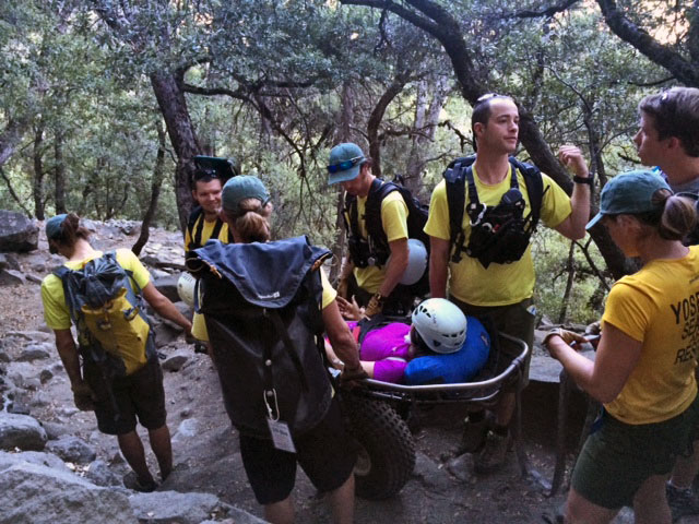 Rescuers surrounding a patient in a wheeled litter
