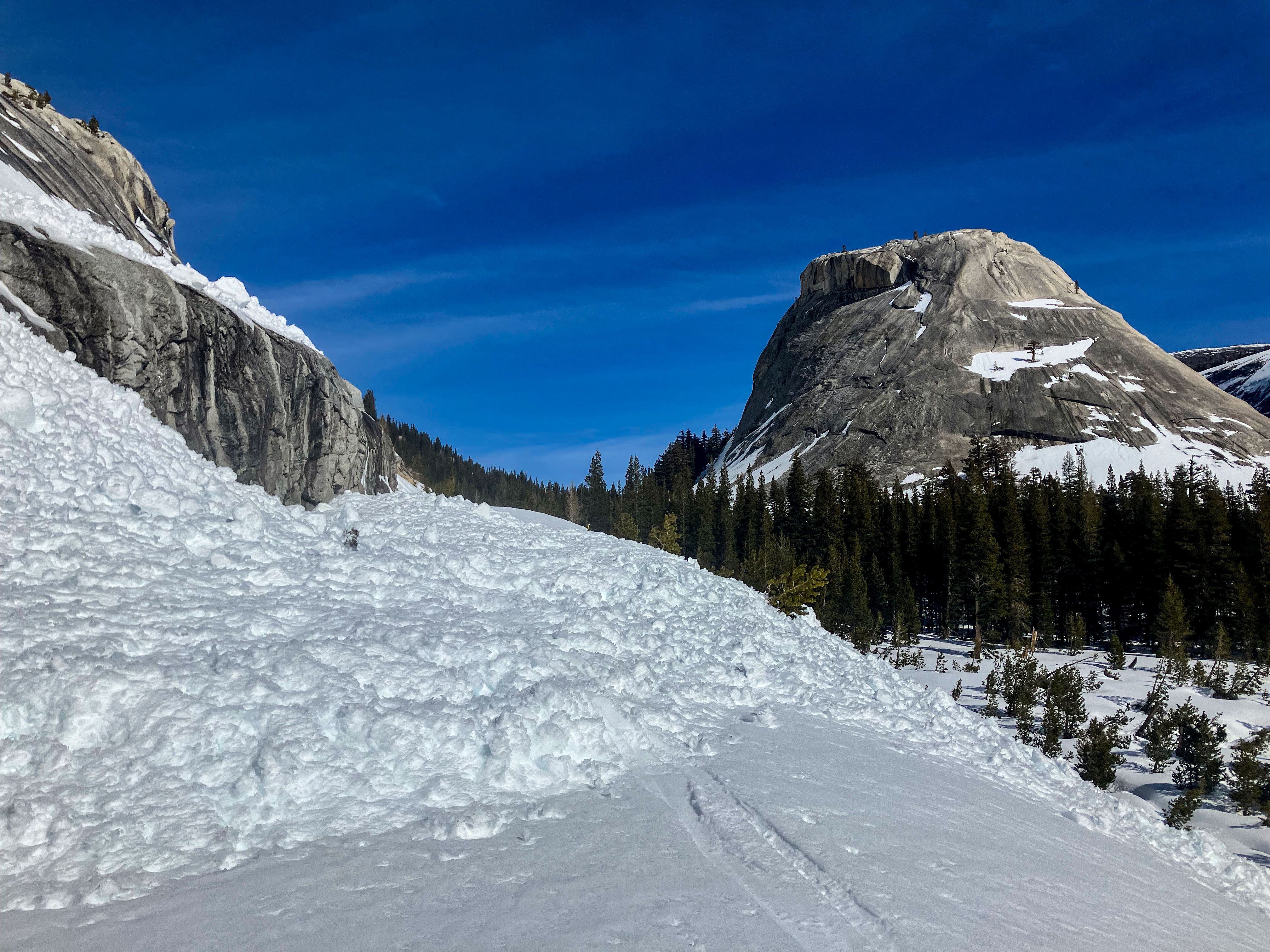 Avalanche across snowy Tioga Road with domes riseing in the background