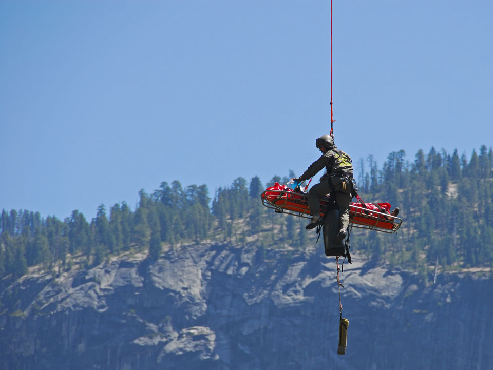 Ranger and patient in litter dangling from a rope