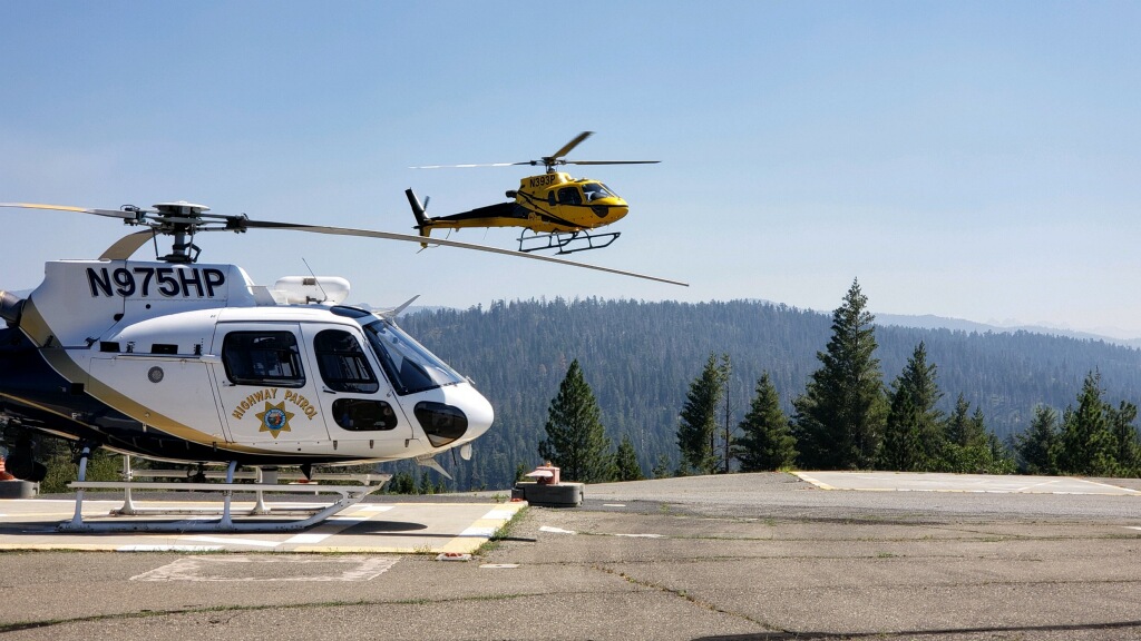 Helicoper in the foreground on ground, helicopter in background in the air