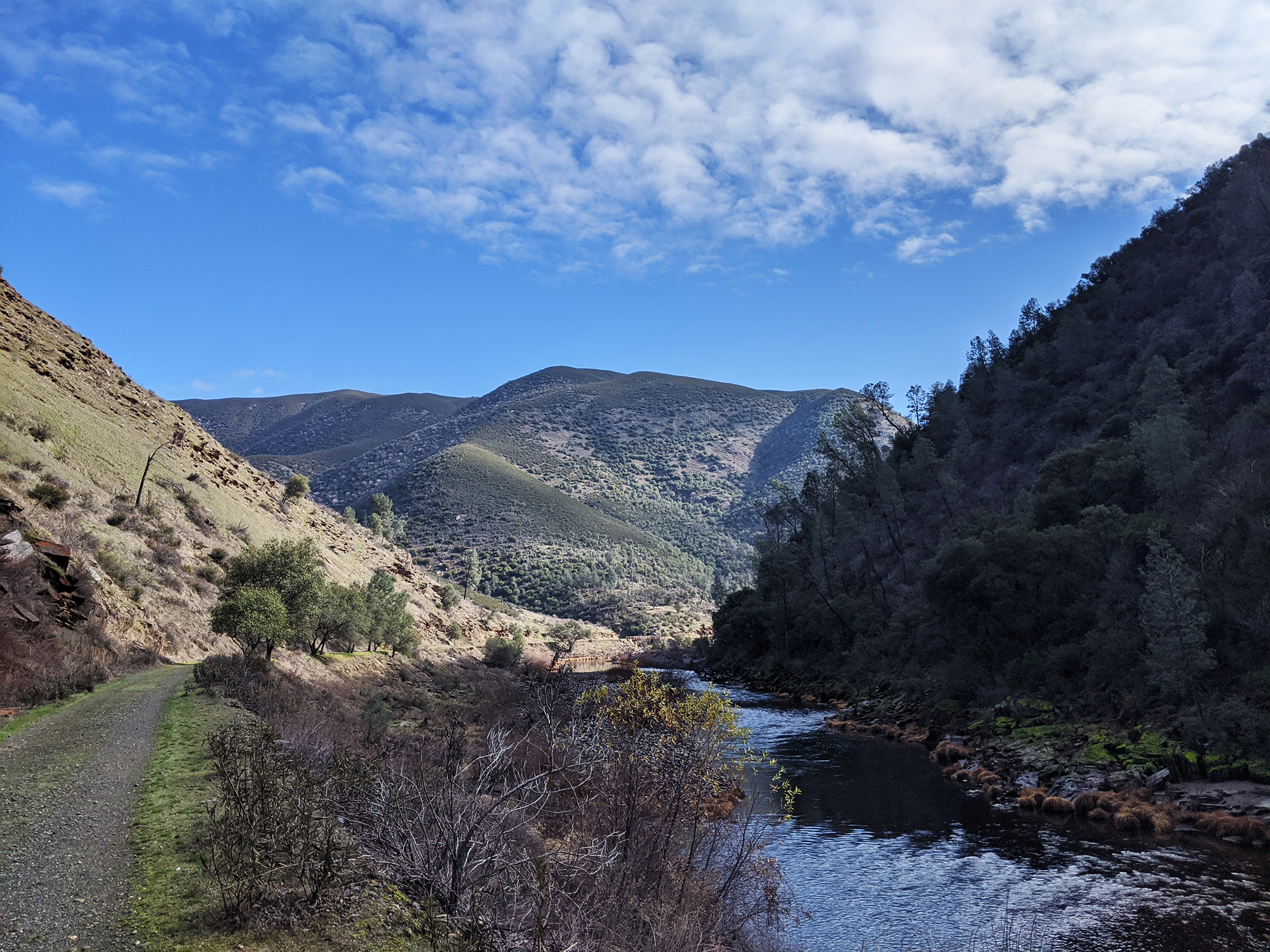 The Merced River runs through a canyon. A narrow path stretches out along the left bank.