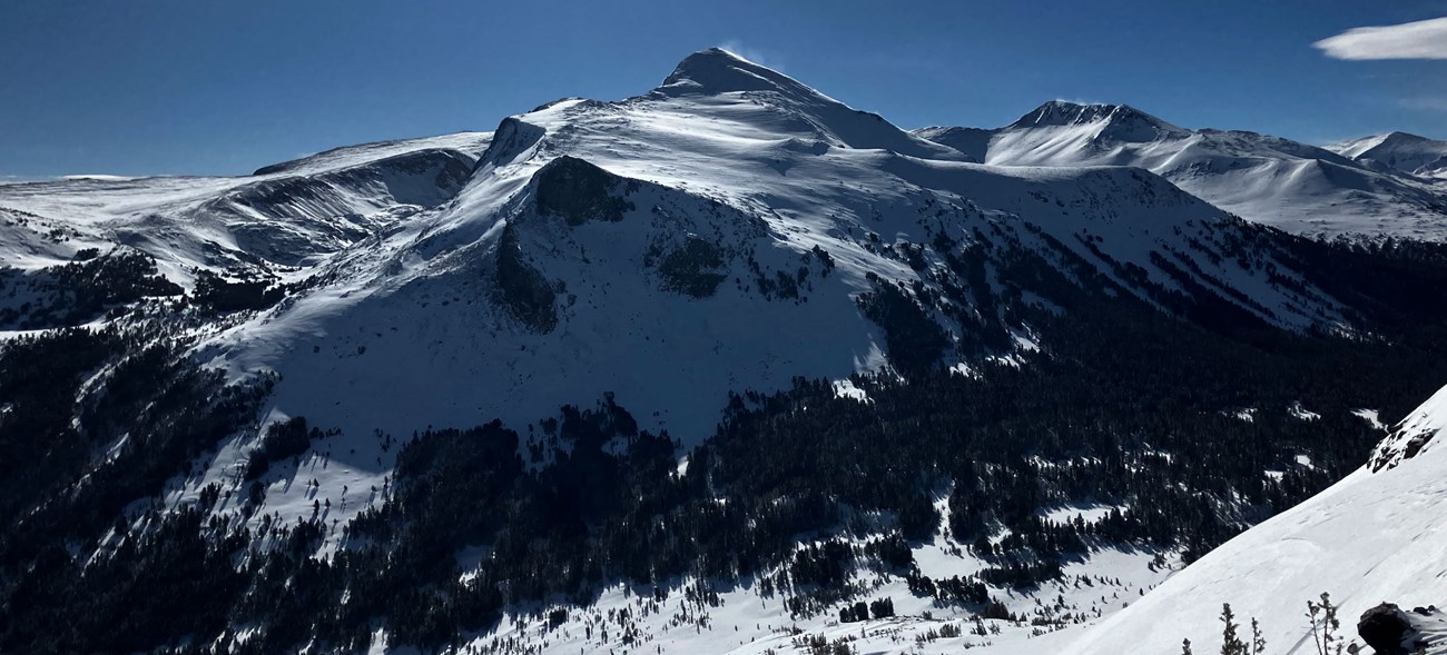 Snowy mountain peak rising above a valley