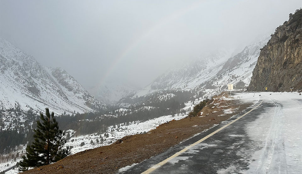 Rainbow in Lee Vining Canyon, some pavement on road showing, some snow. December 30, 2022.