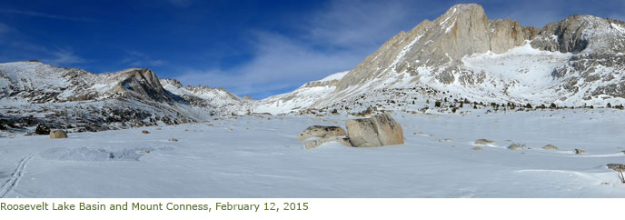 Snow-covered lake with peaks in background