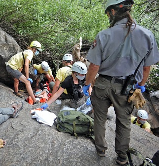 Subject on a litter, being evaluated by a medic.