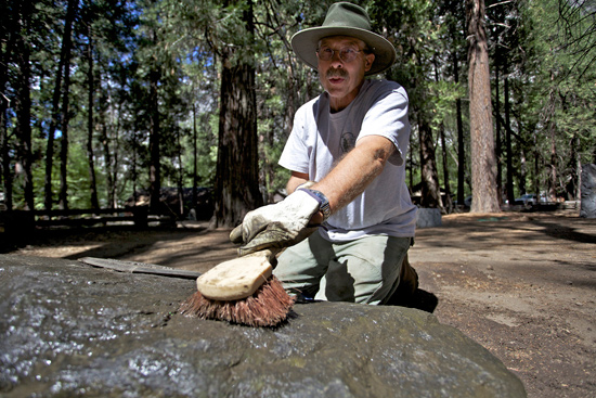 A volunteer scrubs the marker stone of Forest Townsley, Chief Ranger in Yosemite from 1916 until his death in 1943. A volunteer scrubs the marker stone of Forest Townsley, Chief Ranger in Yosemite from 1916 until his death in 1943.