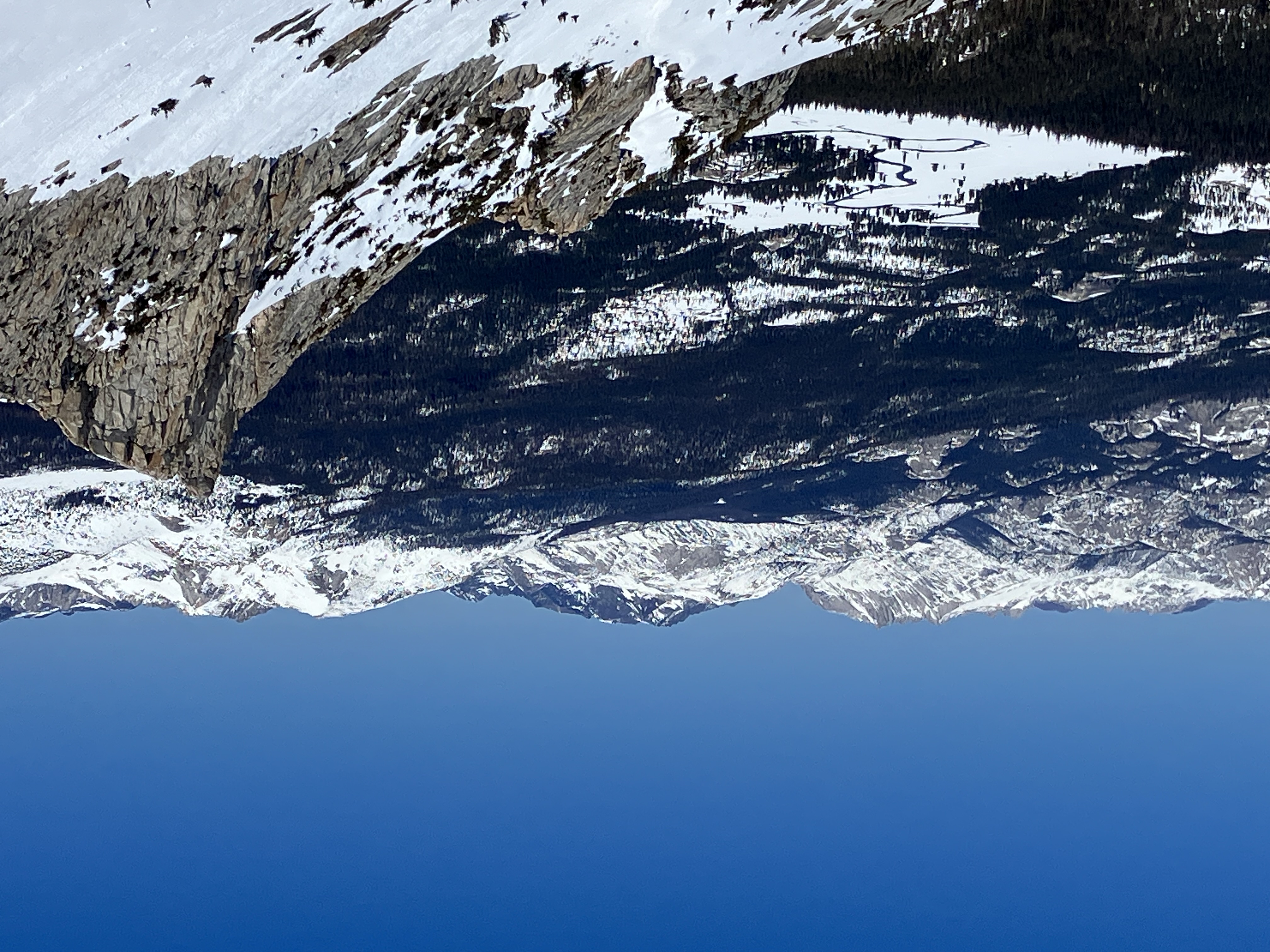 Tuolumne Meadows and Unicorn Peak, April 19th, 2025 Snow-covered Tuolumne Meadows, with a river winding through it, looks small when looking from above and from a distance; it's surrounded by forest and partly snowy peaks