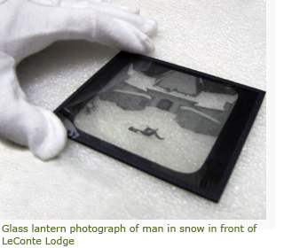Image of glass lantern slide and museum technician's gloved hand holding it. Image of glass lantern slide and museum technician's gloved hand holding it.