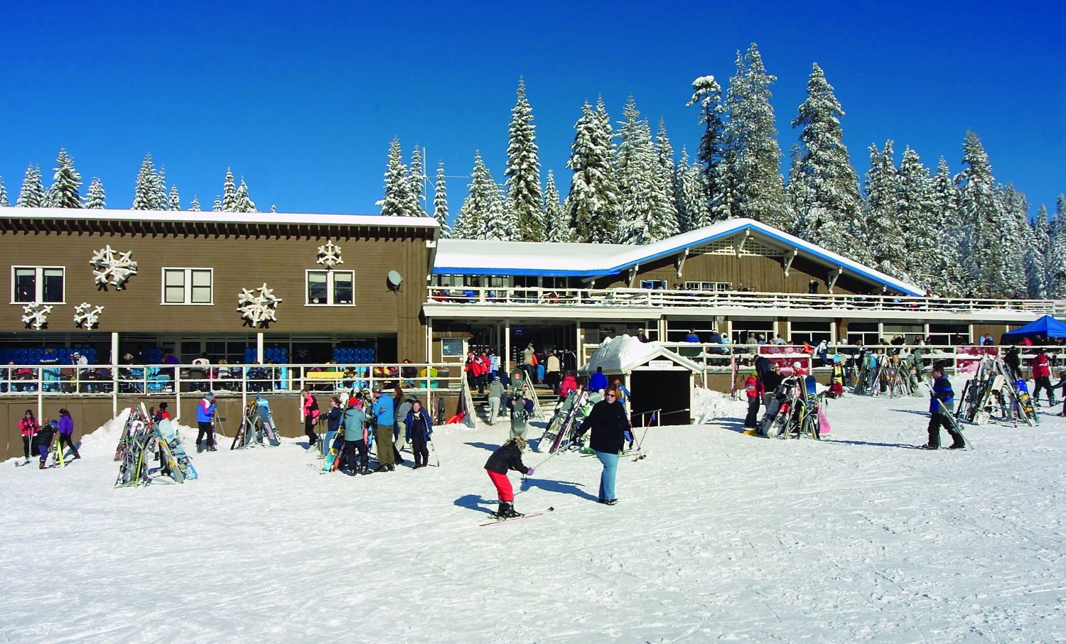 Badger Pass Ski Lodge with skiers and other visitors in foreground