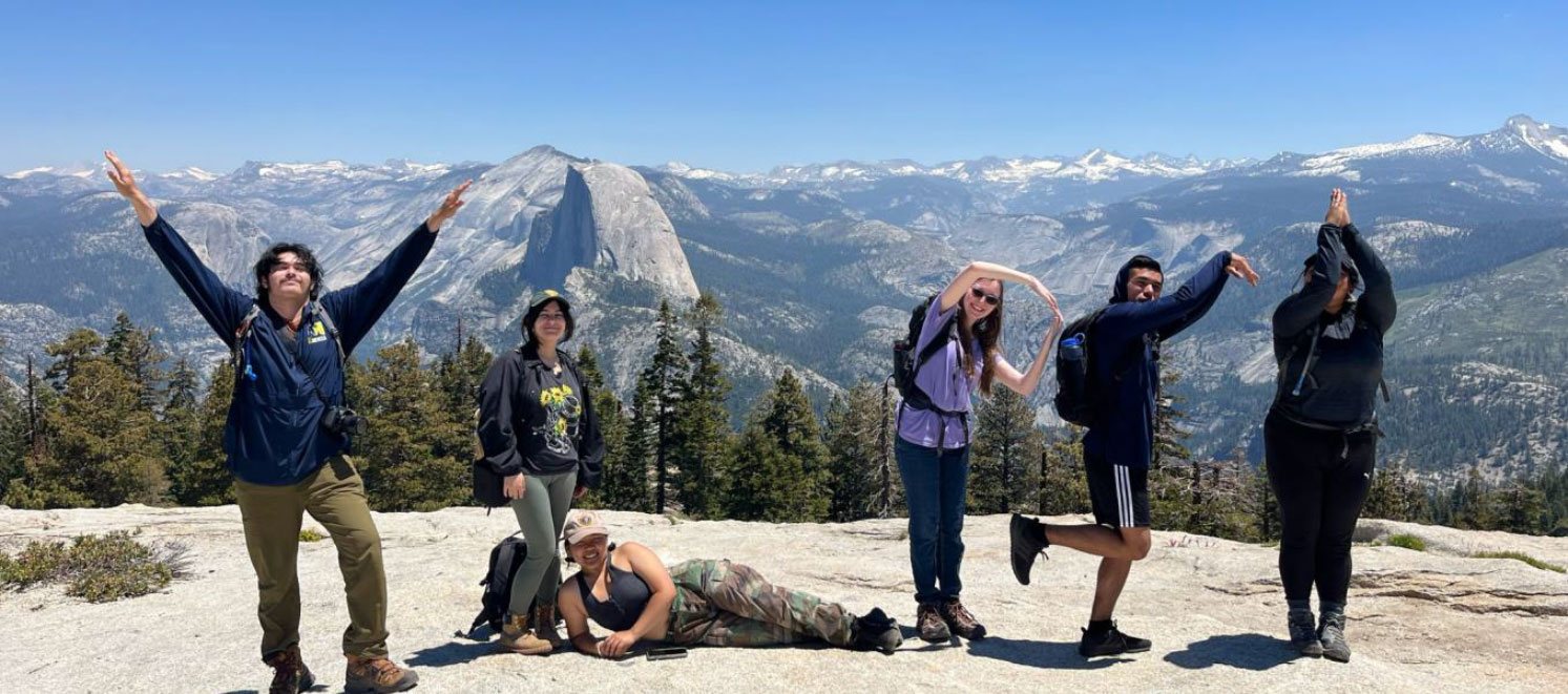 Student interns spelling out YLPSI with their bodies with Half Dome in background
