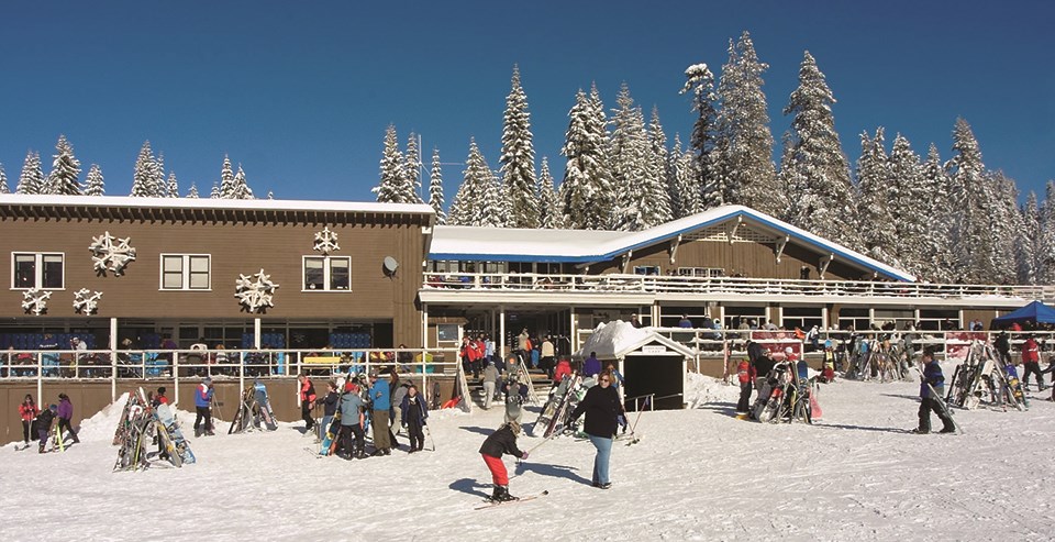 Badger Pass Ski Lodge with skiers and other visitors in foreground