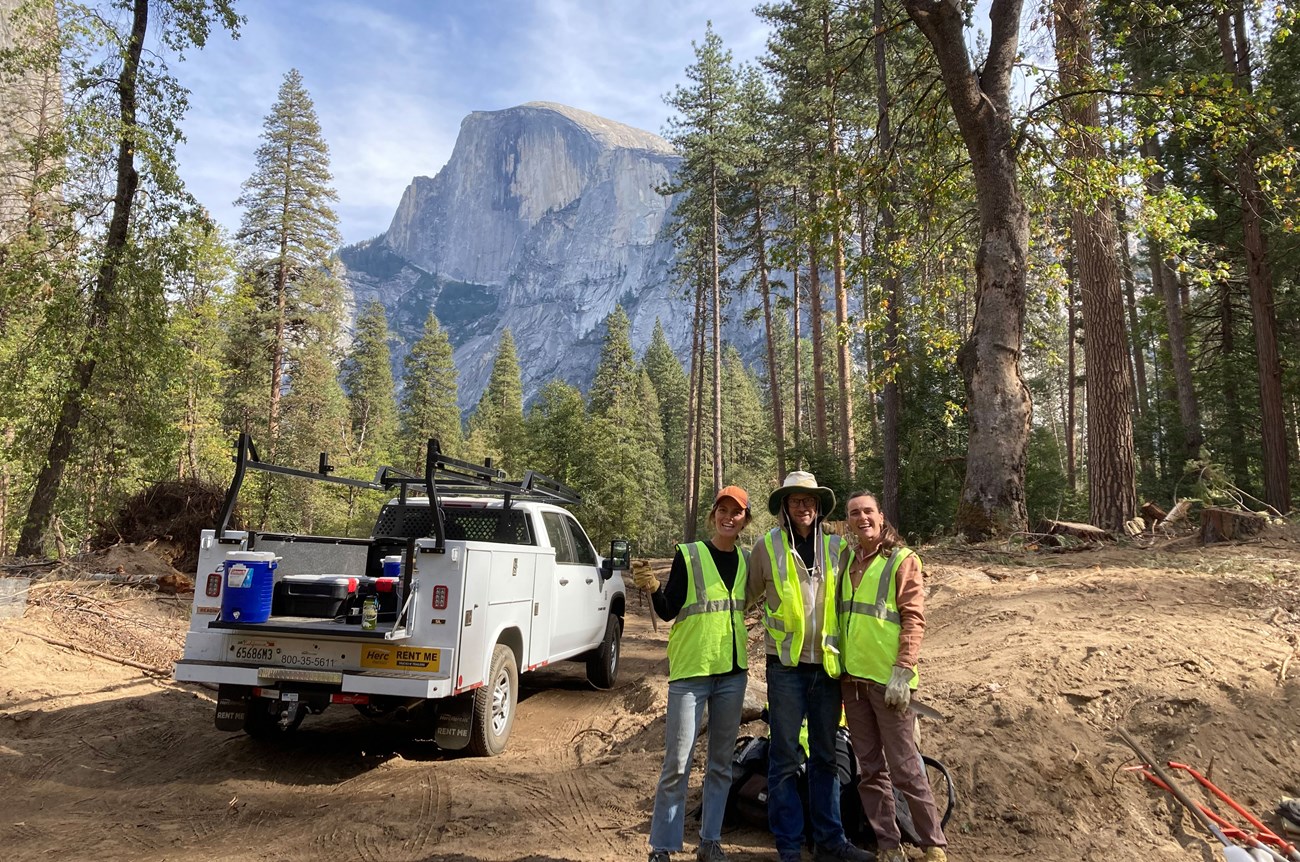 Family members doing restoration volunteer work in Yosemite Valley with Half Dome in the background.