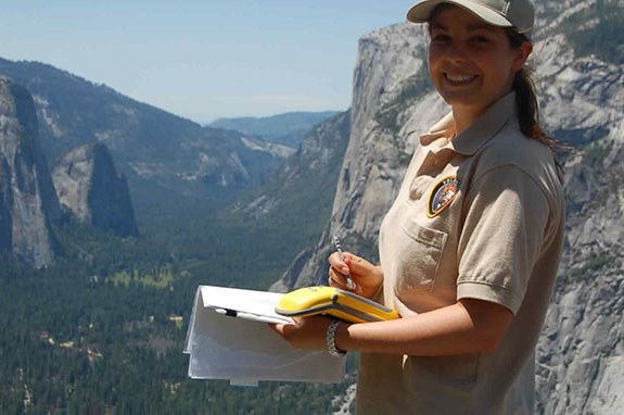 International volunteer working in the park with a GIS unit.