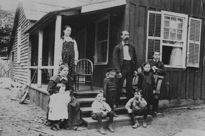 Family of 9 stands on their home's porch