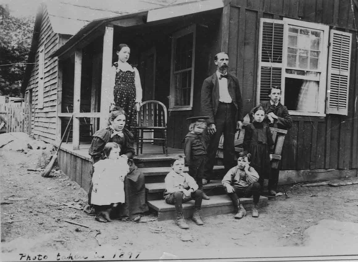 Family of 9 stands on their home's porch