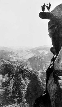 Two women dance on an overhanging rock