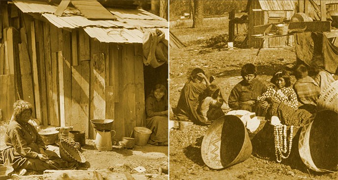 American Indians with baskets posing by their homes.