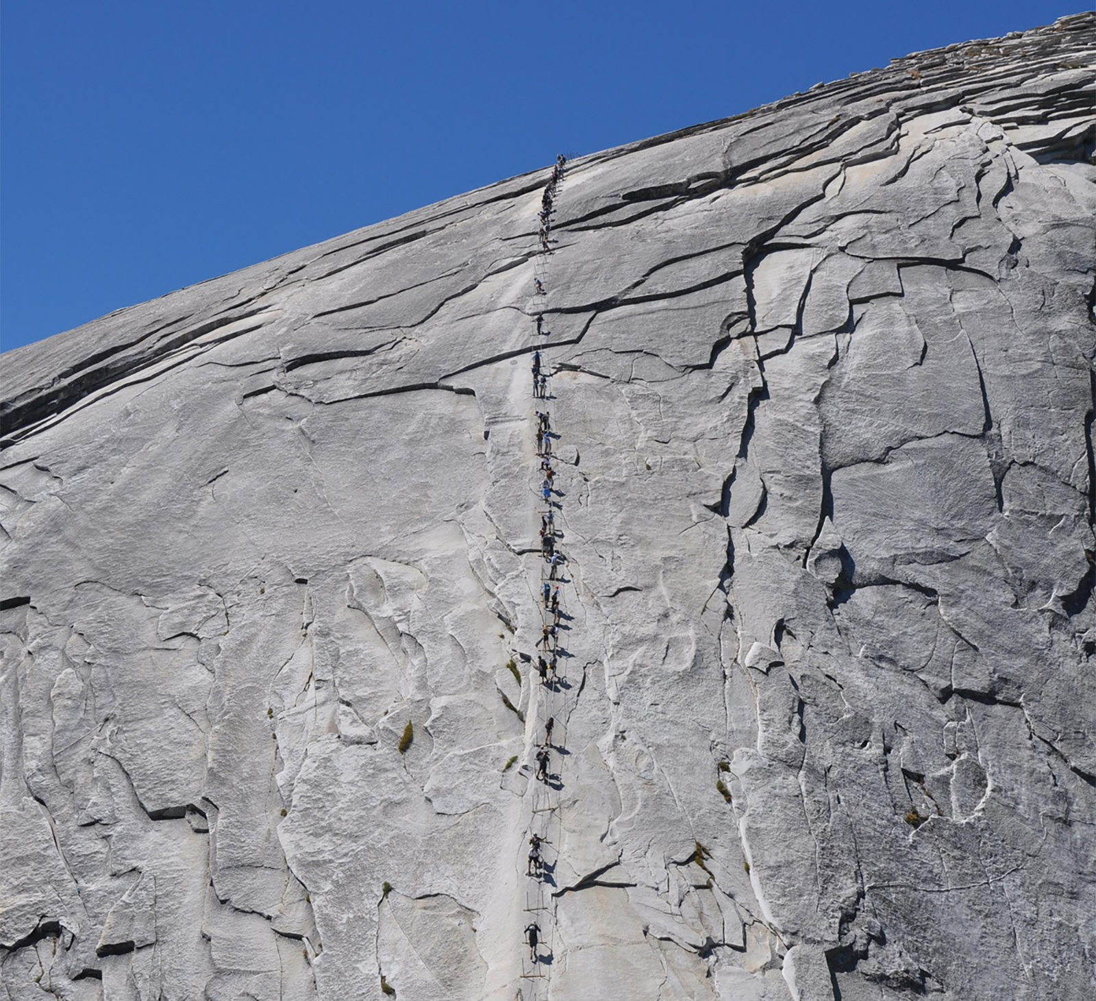 Upper section of Half Dome cables with people climbing up and down
