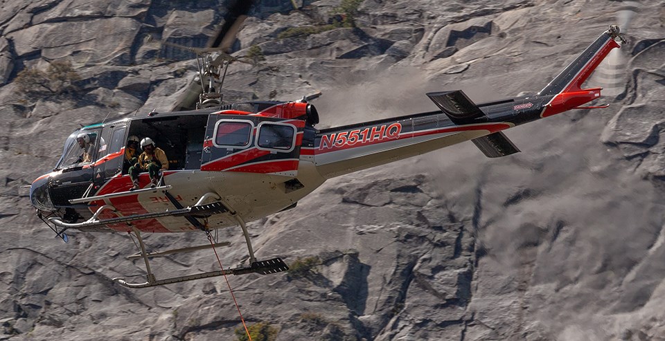 Park helicopter in the air in Yosemite near granite rocks