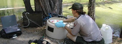 A hydrologist reaches into a water sampling machine A hydrologist reaches into a water sampling machine
