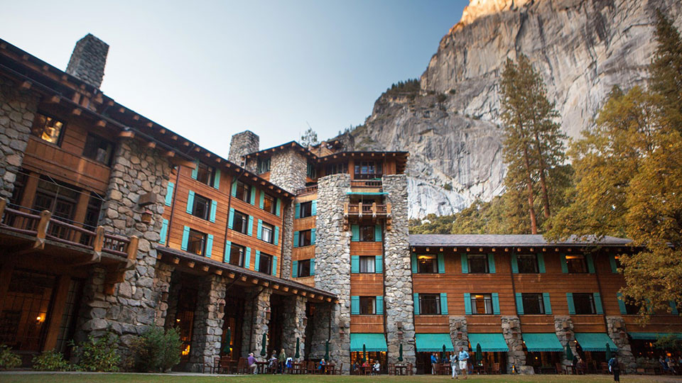 The Ahwahnee with visitors in foreground on lawn and at tables