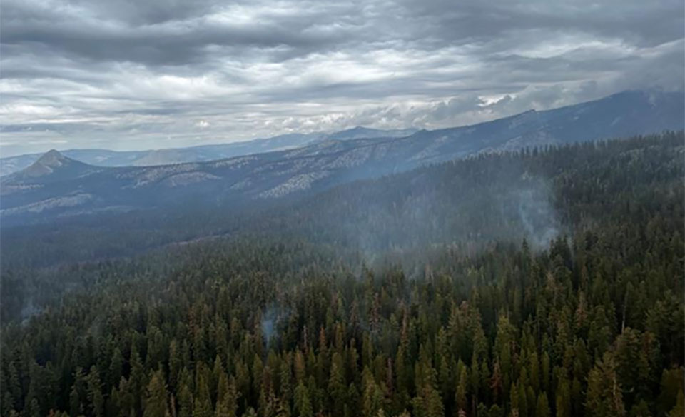 Sky blanketed in clouds and light smoke rising from the Red fire.