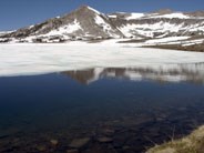 A cirque rises behind a partially snow covered Gaylor Lake