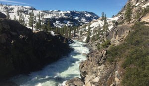 Whitewater river cascades down between granite river banks.