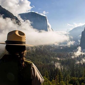 View of the back of a ranger with Yosemite Valley in background.