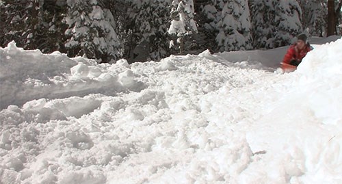 Child sledding down a snowy hill.