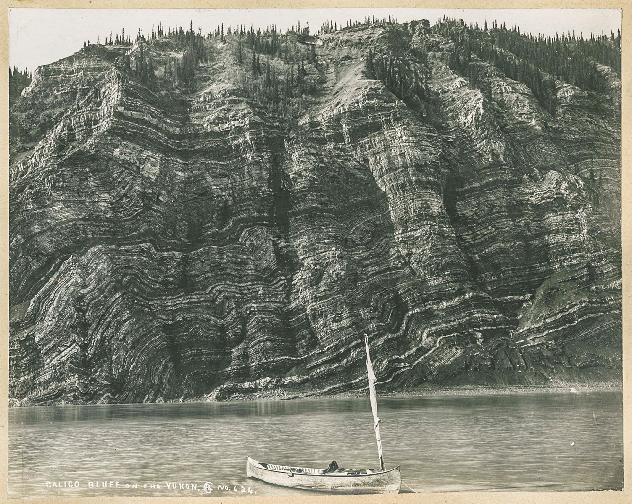 Historic photo of a canoe on shore in front of Calico Bluff