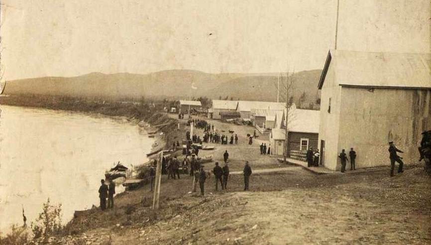 Newly arrived U.S. Army soldiers wander around Eagle City’s waterfront, 1900.