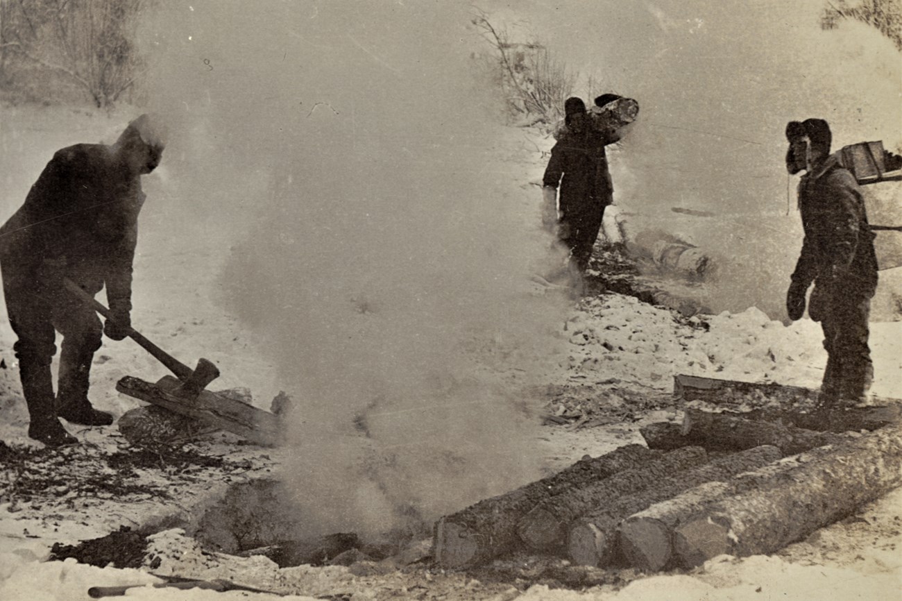 Miners cutting wood to feed the fire in their prospecting shaft, 1898.  After ‘burning down’ through frozen ground, they will continue using fire to ‘drift’ horizontally to reach the richest gold deposits.