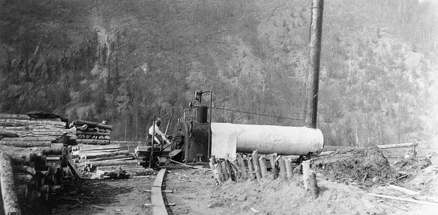 A dredge worker feeding cordwood into the Coal Creek steam boiler, ca. 1935.