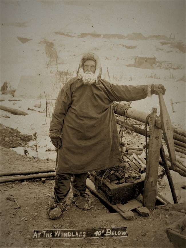 A Klondike miner operating a windlass at forty degrees below zero, ca. 1898.
