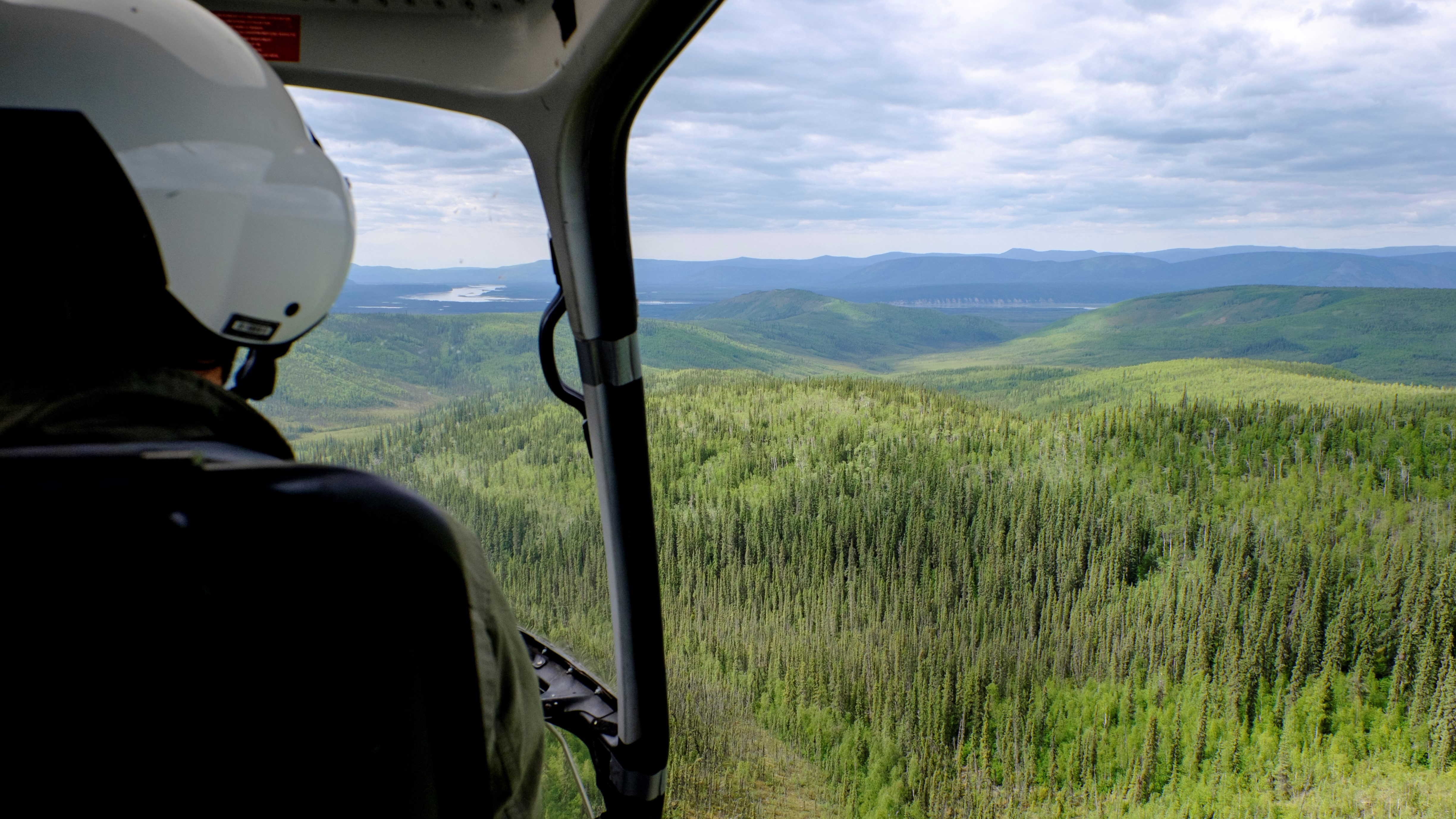 Looking out the open door of a helicopter while in flight, towards Chester Bluff and the Charley and Yukon Rivers confluence Looking out the open door of a helicopter while in flight, towards Chester Bluff and the Charley and Yukon Rivers confluence