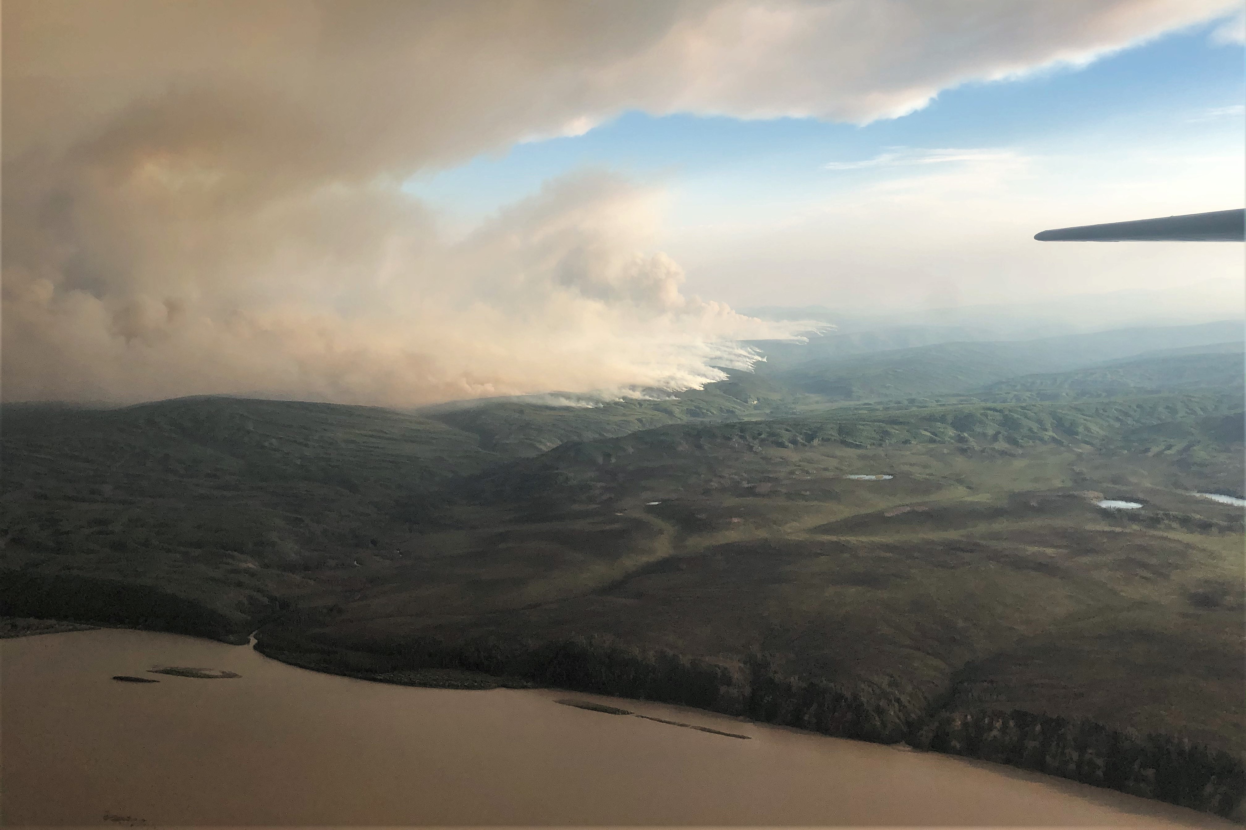 Aerial view of the Cultas Creek Fire #223 burning downslope to Sam Creek. The Sam Creek confluence with the Yukon River is visible in the lower left area of the photo.