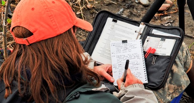 A biologist writes in a notebook