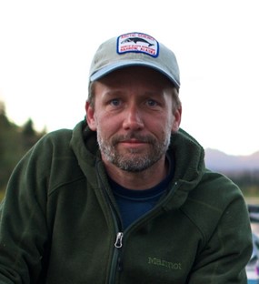 Portrait of a middle-aged man in an outdoor setting wearing a mild expression. Portrait of a middle-aged man in an outdoor setting wearing a mild expression that looks either contemplative or melancholic.