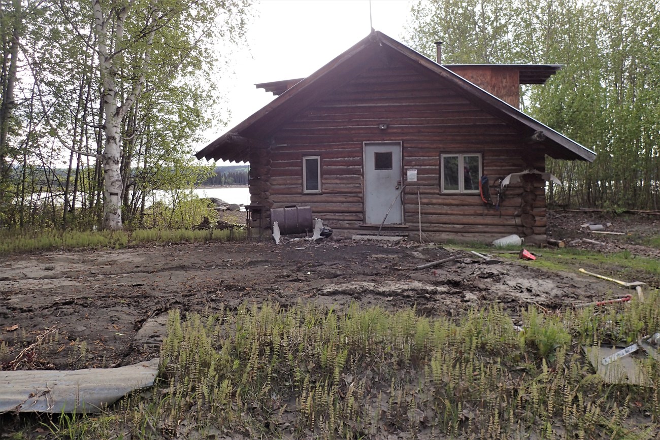 Smith Public Use Cabin site showing the cabin moved off its foundation and rotated, June 2, 2023.