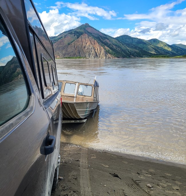 Launching a boat into the Yukon River with Eagle Bluff in the background
