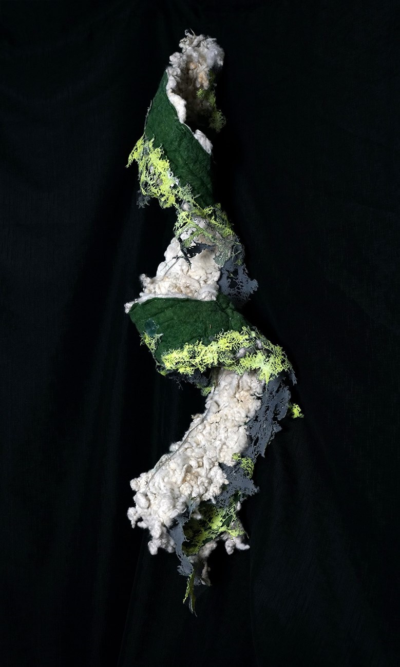 green and white fabric coiled on a black background