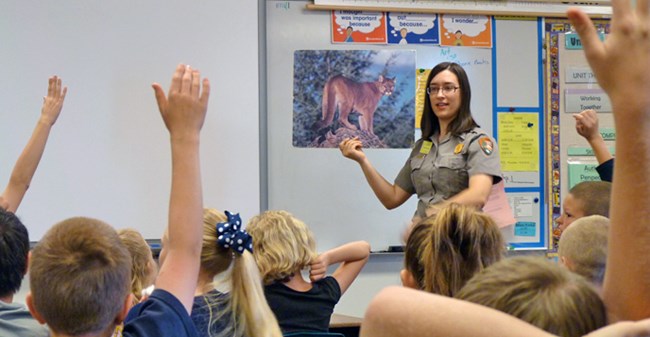 A park ranger talking to students in a classroom
