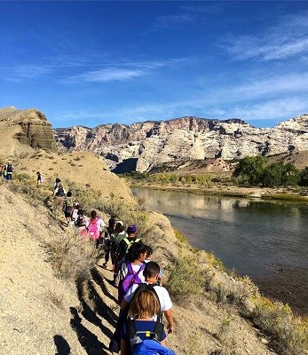 Students hiking on a trail near a river